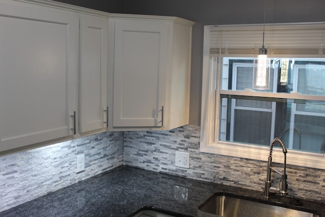 kitchen featuring sink, backsplash, and white cabinets