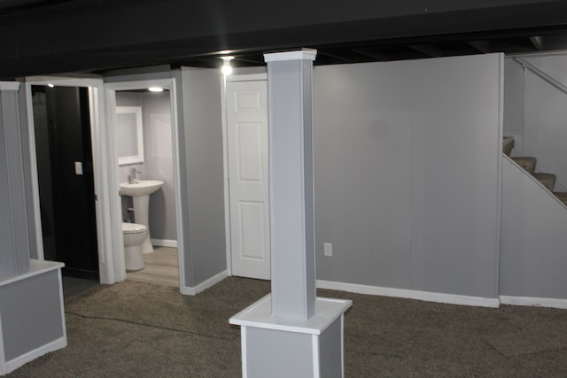 basement featuring sink and dark carpet