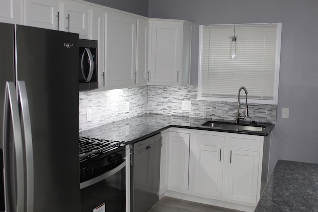 kitchen with sink, appliances with stainless steel finishes, white cabinetry, hanging light fixtures, and tasteful backsplash