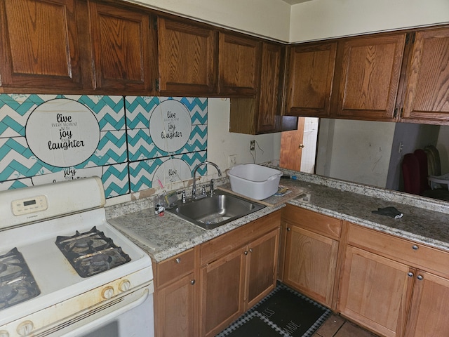 kitchen with tasteful backsplash, sink, white gas range oven, and dark stone countertops