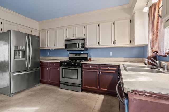 kitchen with ornamental molding, appliances with stainless steel finishes, and sink