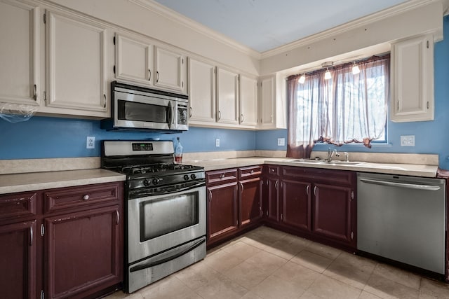 kitchen with crown molding, appliances with stainless steel finishes, sink, and light tile patterned floors