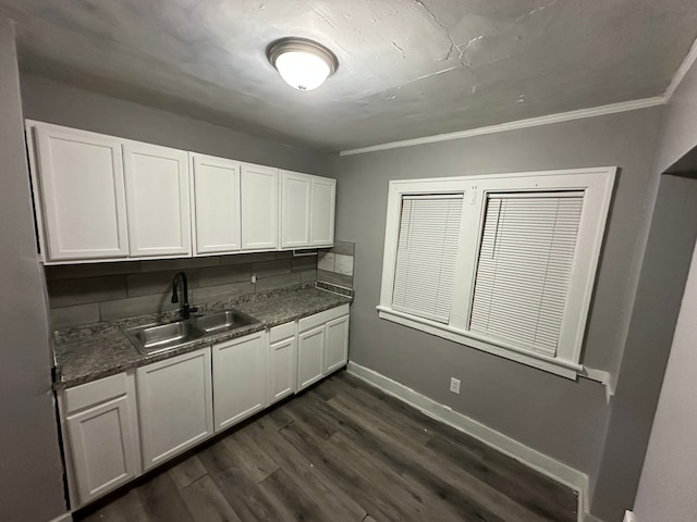 kitchen featuring dark wood-type flooring, sink, white cabinetry, crown molding, and decorative backsplash