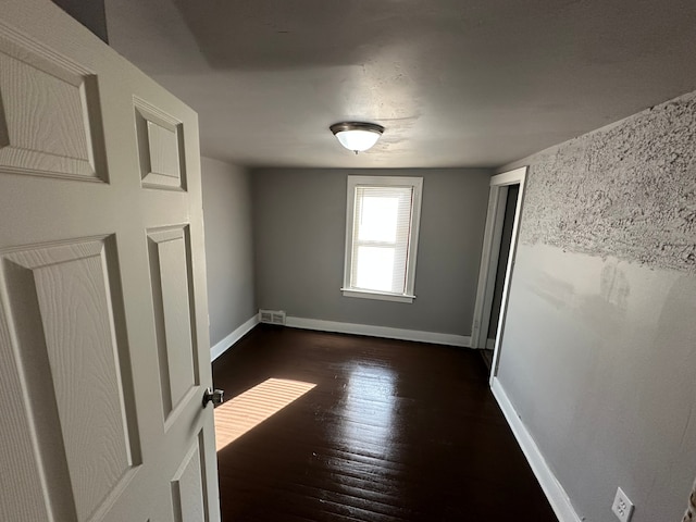 empty room with dark hardwood / wood-style floors