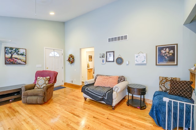 living room featuring high vaulted ceiling and light wood-type flooring