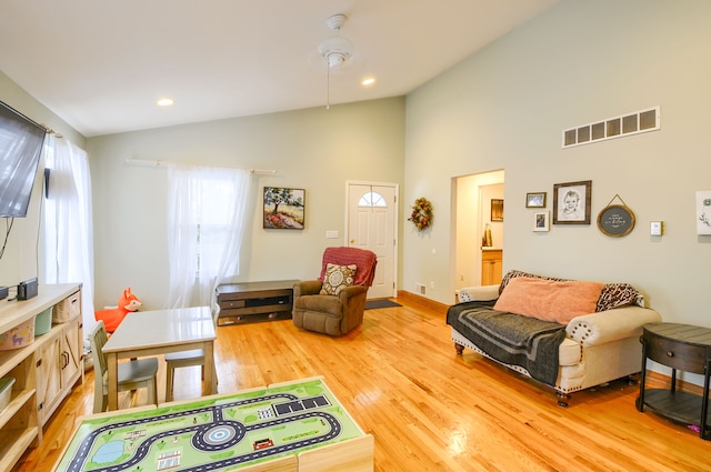 living room with hardwood / wood-style floors and high vaulted ceiling