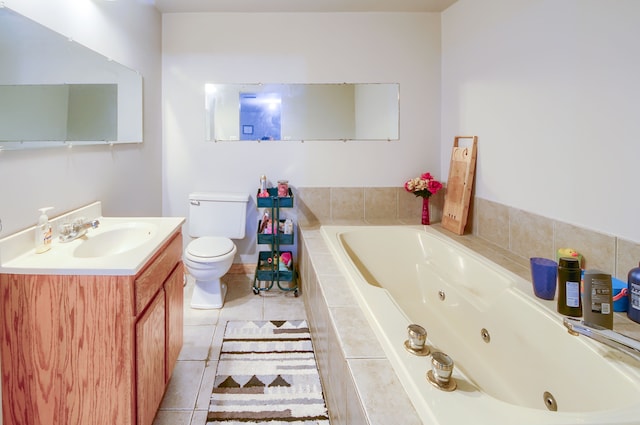 bathroom with tile patterned flooring, vanity, tiled tub, and toilet