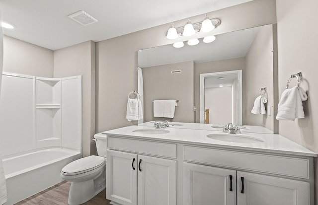 full bathroom featuring toilet, a sink, double vanity, and visible vents