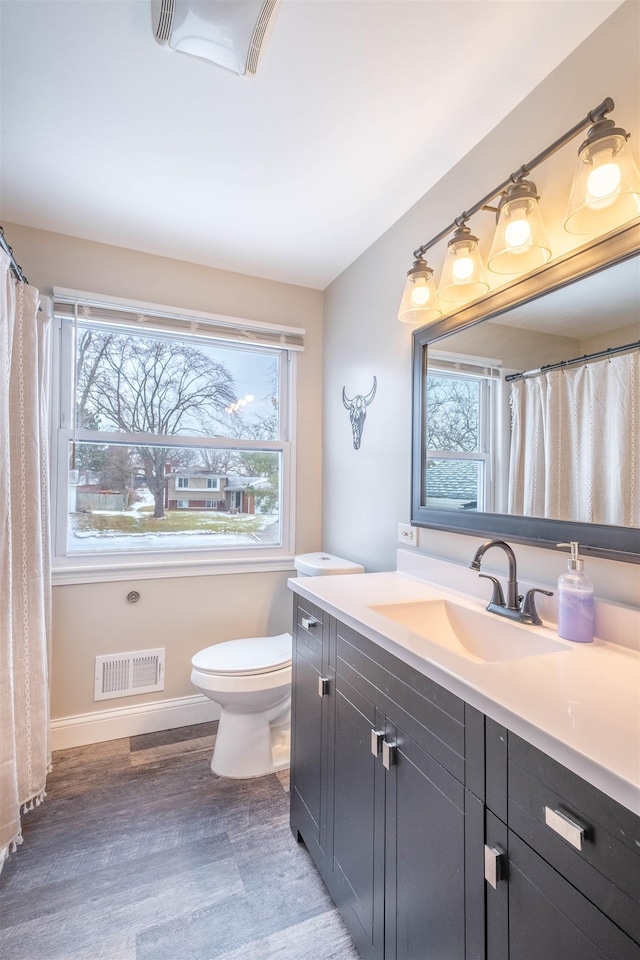 bathroom with vanity, toilet, and hardwood / wood-style floors