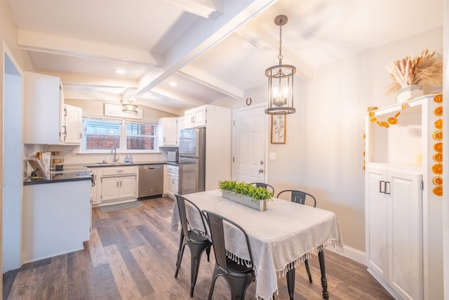 dining space featuring sink, dark wood-type flooring, and lofted ceiling with beams