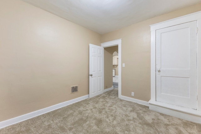 spare room featuring light colored carpet