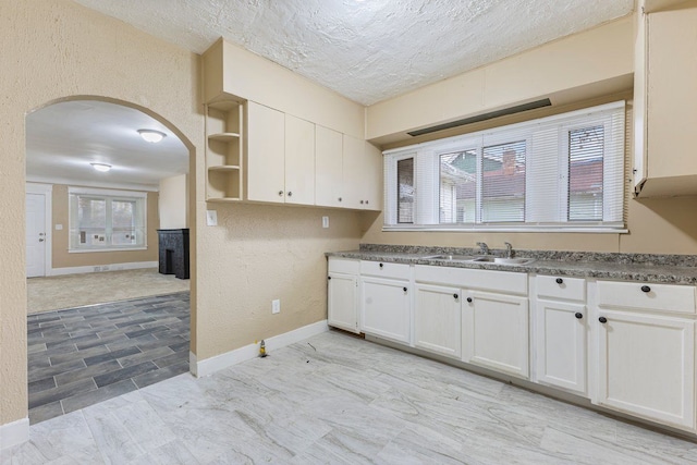 kitchen featuring sink, a textured ceiling, and white cabinets