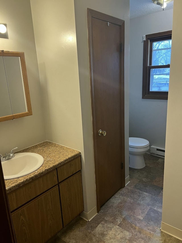 bathroom with vanity, a textured ceiling, a baseboard radiator, and toilet