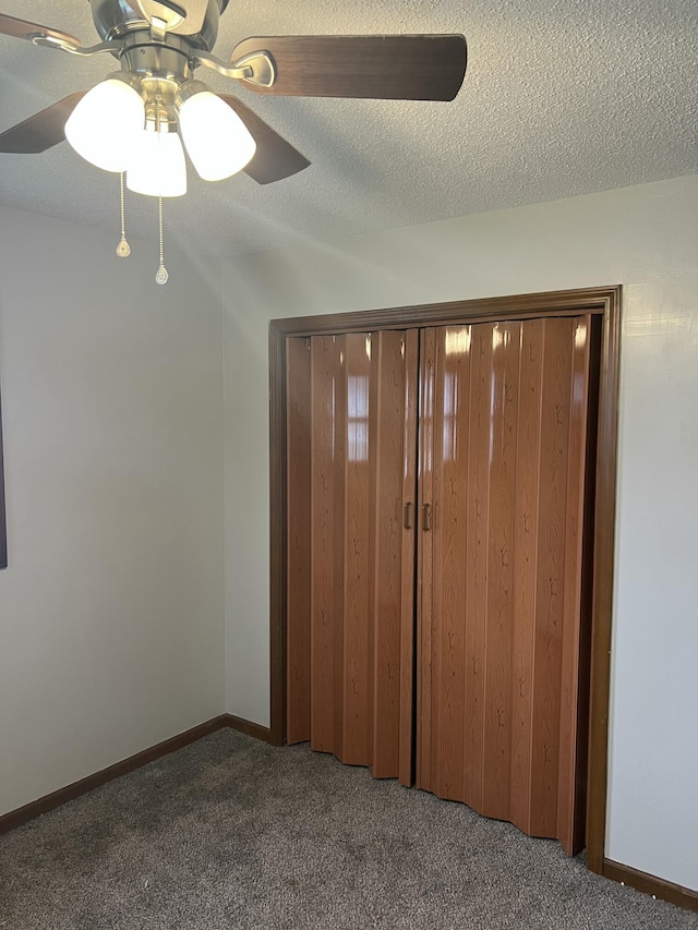 unfurnished bedroom with ceiling fan, a closet, carpet, and a textured ceiling