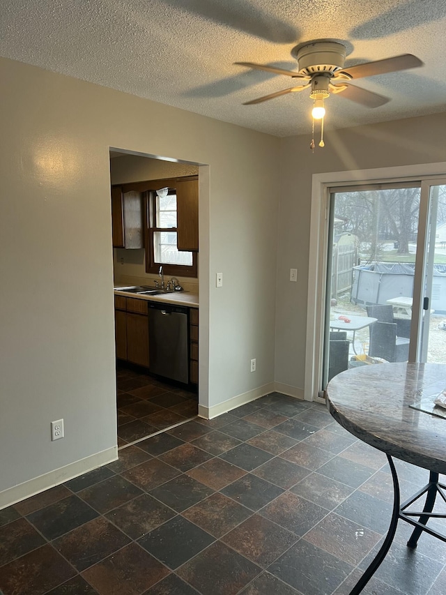 unfurnished dining area featuring ceiling fan, sink, and a textured ceiling