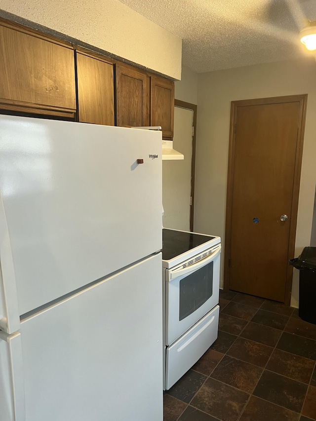 kitchen featuring white appliances and a textured ceiling