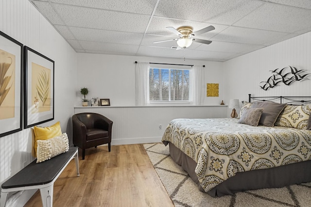 bedroom featuring ceiling fan, a paneled ceiling, and wood-type flooring