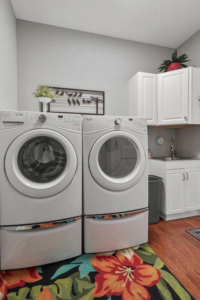 washroom featuring cabinets, wood-type flooring, washer and dryer, and sink