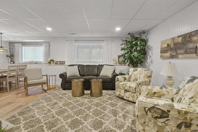 living room with a paneled ceiling and hardwood / wood-style floors