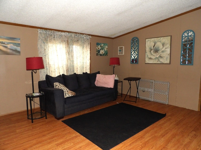 living room featuring lofted ceiling, ornamental molding, and wood-type flooring