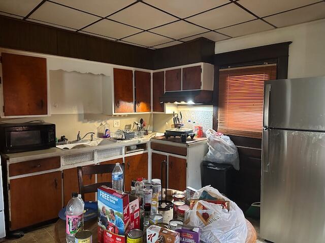 kitchen featuring stainless steel fridge and a paneled ceiling