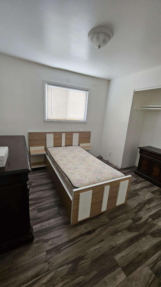 bedroom with dark hardwood / wood-style flooring