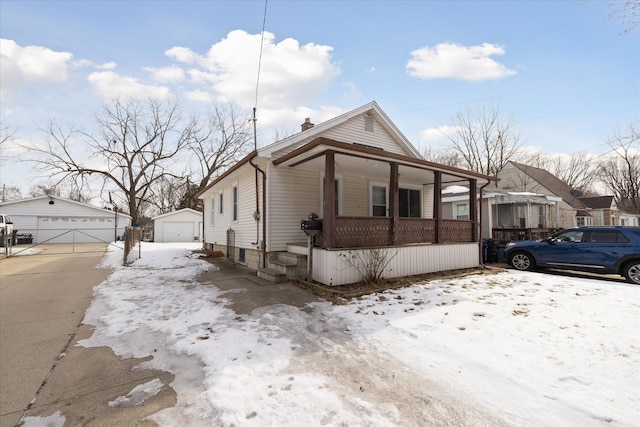 view of front of property with a garage, an outdoor structure, and covered porch