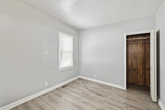 unfurnished bedroom featuring light hardwood / wood-style floors and a closet