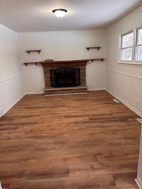 unfurnished living room with hardwood / wood-style floors and a fireplace