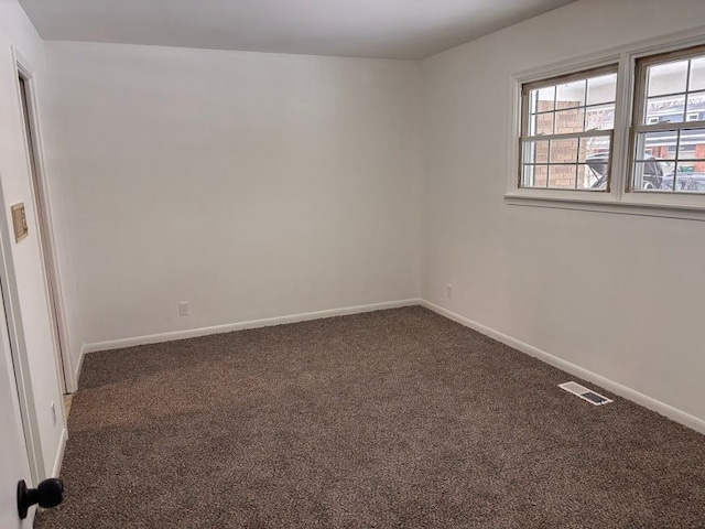 empty room featuring dark carpet