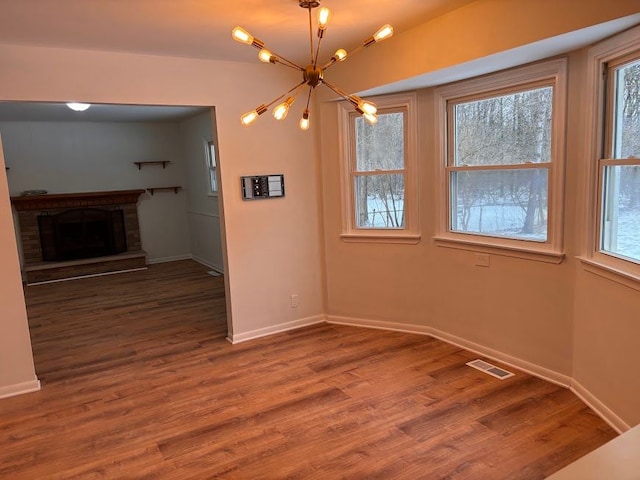 unfurnished dining area with plenty of natural light, hardwood / wood-style floors, and a fireplace