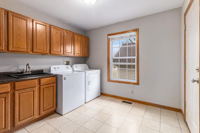 laundry area featuring sink, washer and clothes dryer, and cabinets