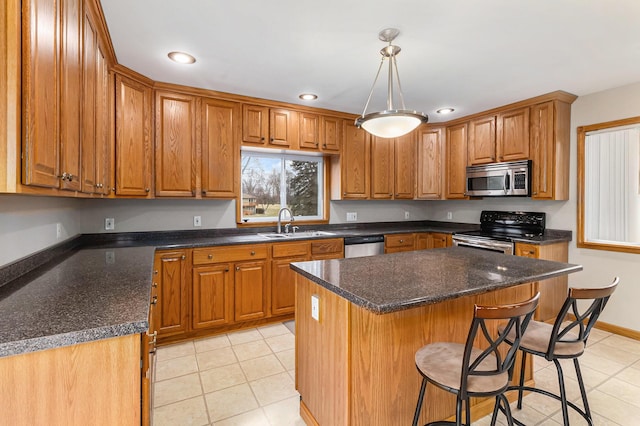 kitchen with decorative light fixtures, sink, a center island, light tile patterned floors, and stainless steel appliances