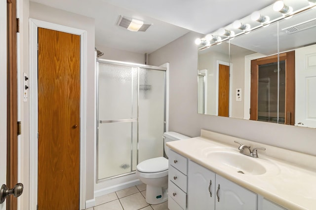 bathroom featuring an enclosed shower, vanity, tile patterned floors, and toilet