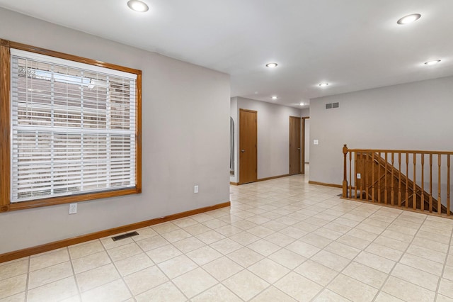 empty room with light tile patterned floors and a wealth of natural light