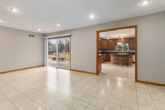 spare room featuring light tile patterned floors and a textured ceiling