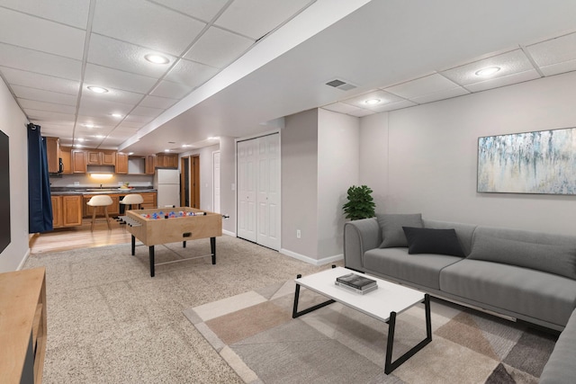 living room featuring a paneled ceiling and light colored carpet