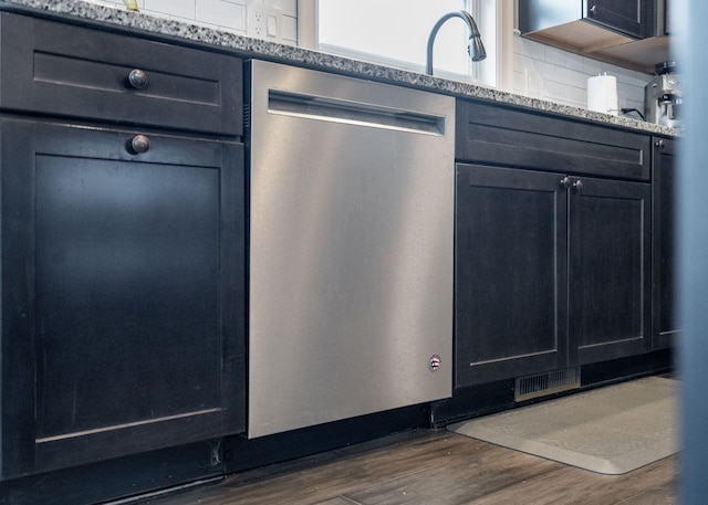 kitchen featuring backsplash, light stone countertops, dark hardwood / wood-style floors, and dishwasher