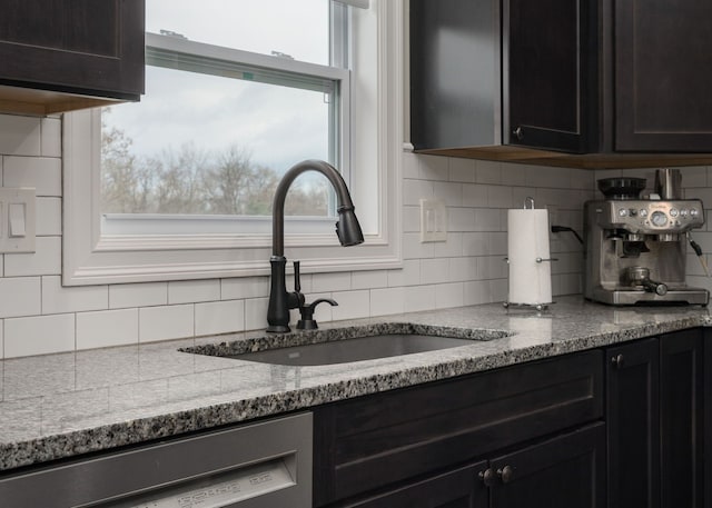 kitchen featuring light stone counters, sink, tasteful backsplash, and dishwasher