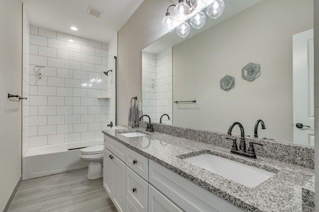 full bathroom featuring vanity, toilet, and tiled shower / bath combo