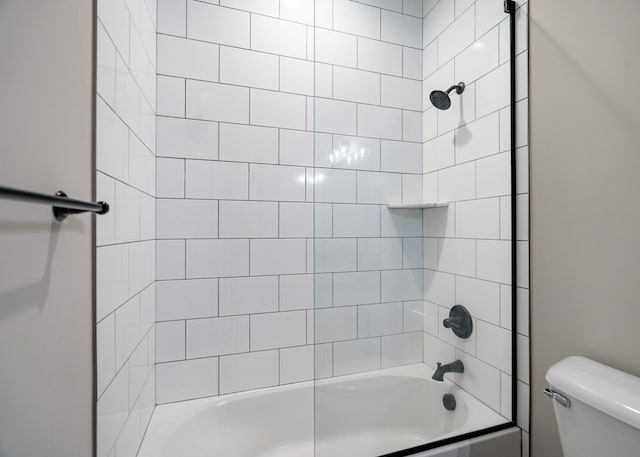 bathroom featuring toilet and tiled shower / bath