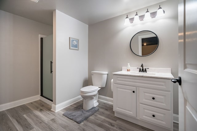 bathroom with a shower with door, wood-type flooring, vanity, and toilet