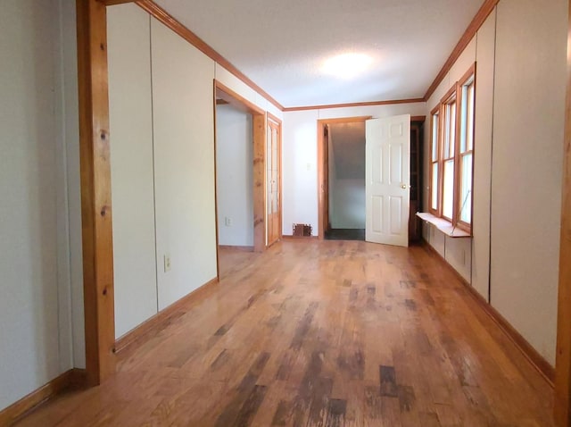 interior space with crown molding and light hardwood / wood-style flooring