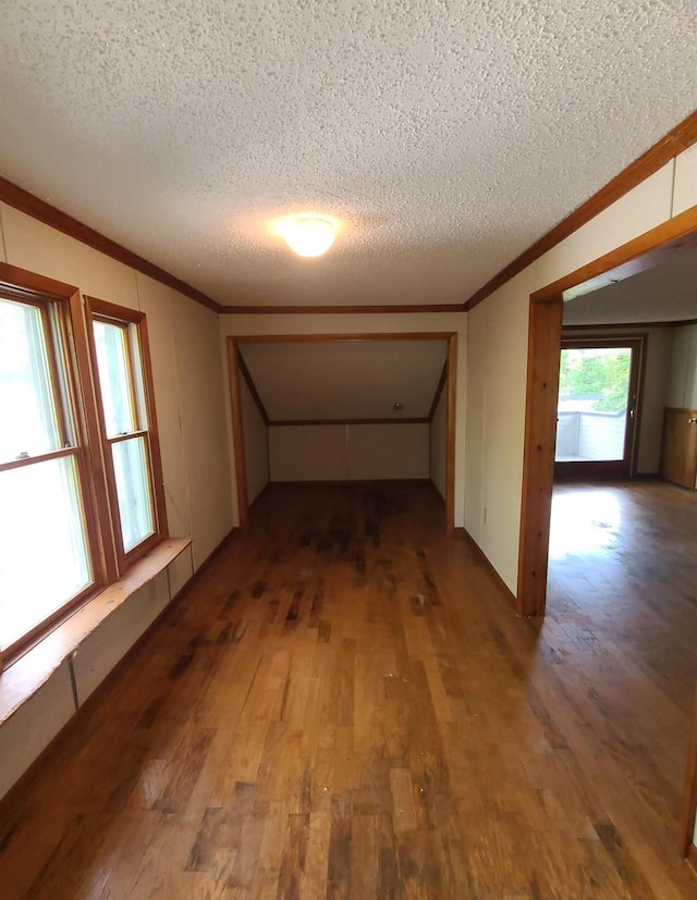 interior space with crown molding, hardwood / wood-style floors, and a textured ceiling