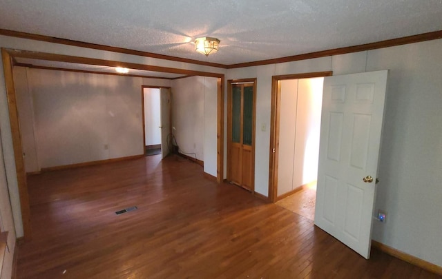 unfurnished room with crown molding, wood-type flooring, and a textured ceiling