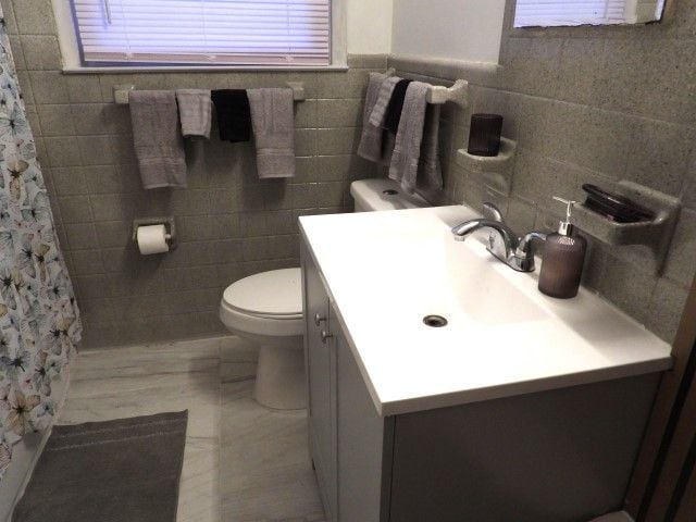 bathroom featuring vanity, a shower with curtain, tile walls, and toilet