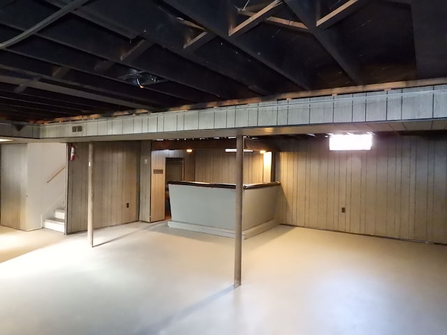 basement featuring wood walls