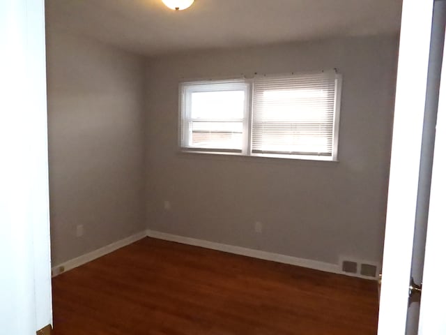 empty room with dark hardwood / wood-style floors