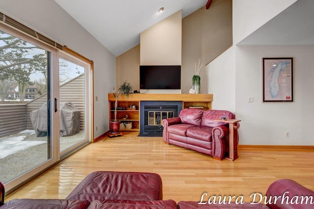 living room with hardwood / wood-style floors and high vaulted ceiling