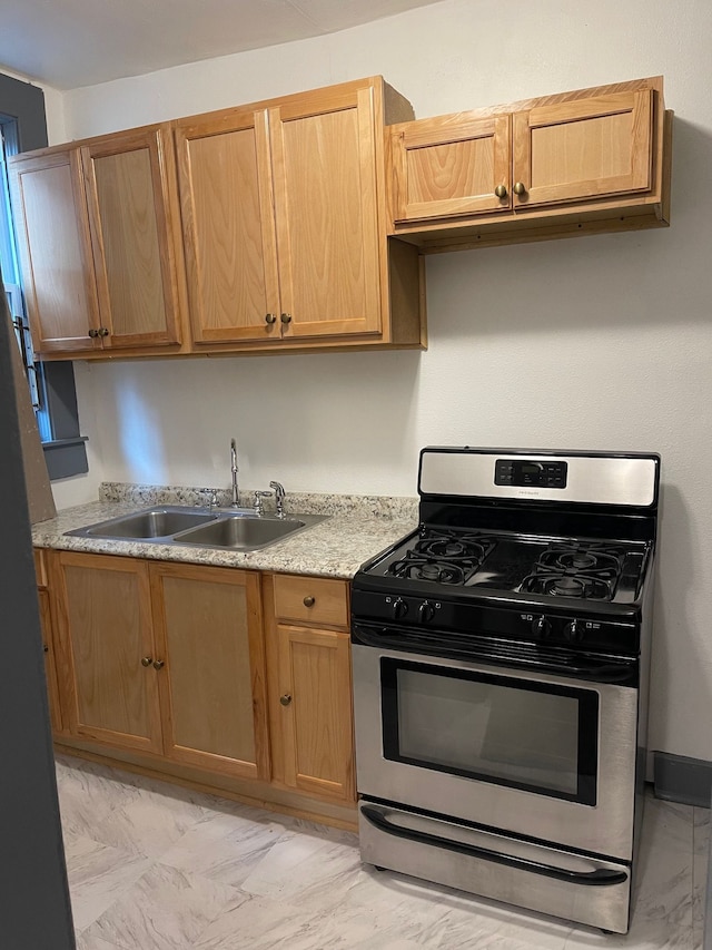 kitchen with light stone counters, sink, and gas stove